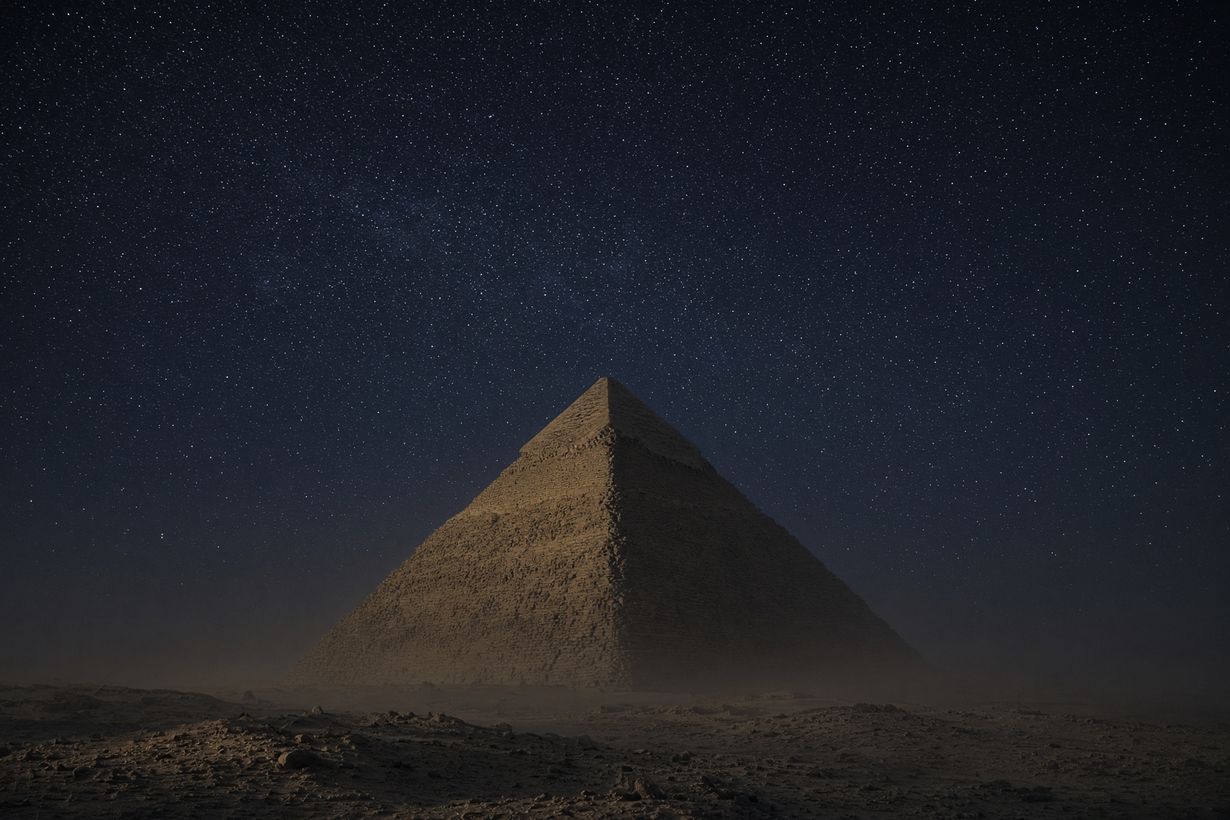 A pyramid at night, the sky full of stars, none of them sitting at the exact top of the frame.
