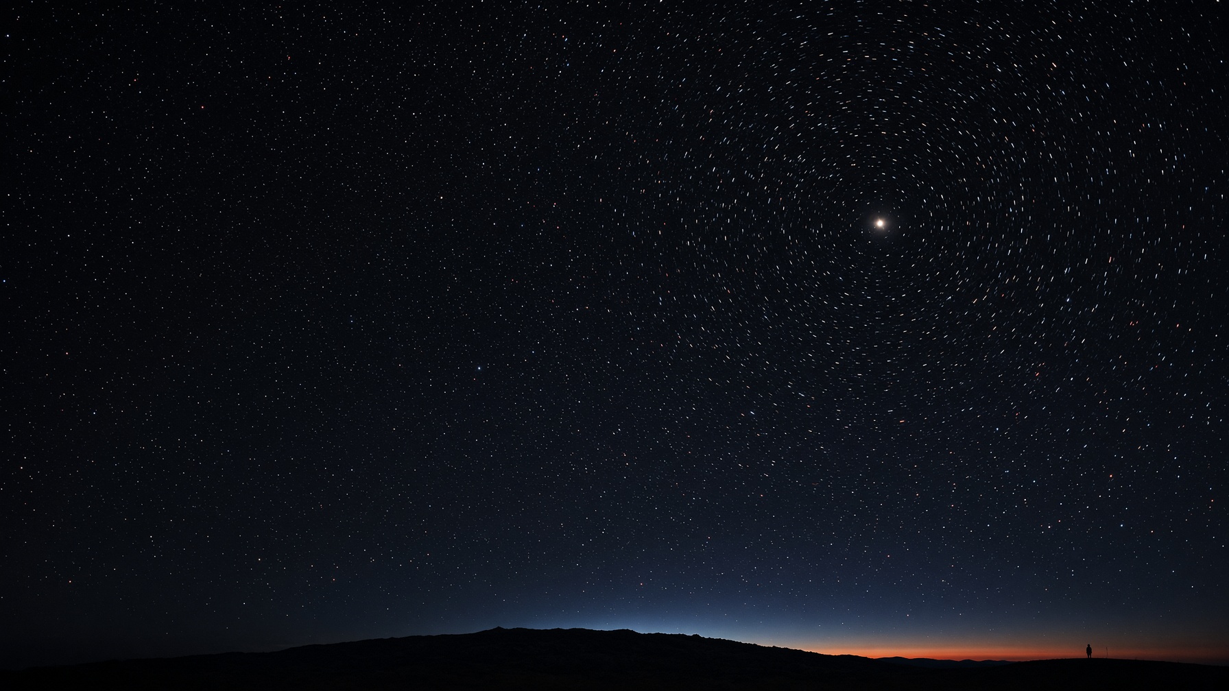 A tiny figure on a dark ridge, under a black sky of red, blue, and white points.